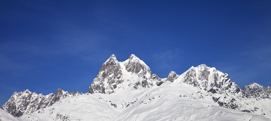 Fototapeta na wymiar Panoramic view on snowy mountains and blue sky at sunny winter day