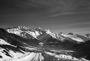 Obraz premium Snowy road and mountain in haze at early winter morning