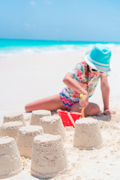 Adorable little girl playing with beach toys during tropical vacation