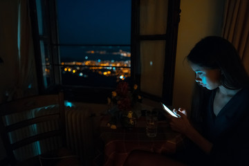 Woman using smart phone for online at home in evening