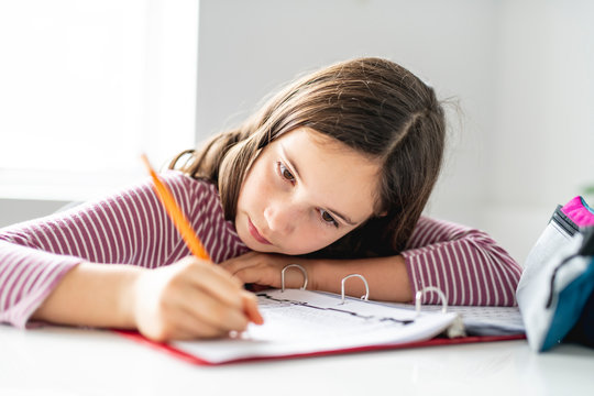 A schoolgirl doing homework on the diner table