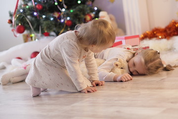 Merry Christmas and Happy Holidays Cute little child girl is decorating the Christmas tree indoors.