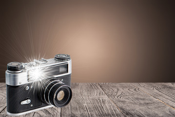 retro camera on a wooden surface with flash