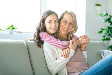 A Portrait of a beautiful mother and her little girl sitting at home and sharing a happy moment together.