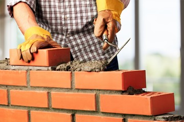 Worker builds a brick wall