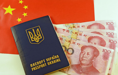 Ukrainian passport and yuans on background China flag