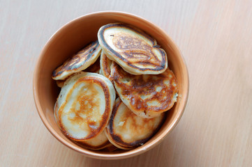 Brown bowl full of pancakes.