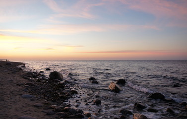 Fototapeta na wymiar Sonnenuntergang am Strand mit Wellen und Sand an der Ostsee nahe Warnemünde im Urlaub