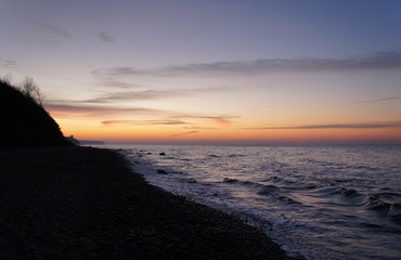 Sonnenuntergang am Strand mit Wellen und Sand an der Ostsee nahe Warnemünde im Urlaub