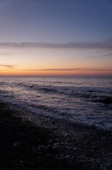 Sonnenuntergang am Strand mit Wellen und Sand an der Ostsee nahe Warnem&uuml;nde im Urlaub