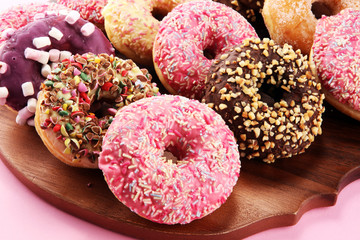 assorted donuts with chocolate frosted, pink glazed and sprinkles donuts