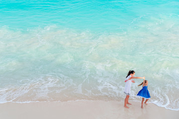 Mother and little daughter enjoying time at tropical beach