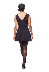 Fototapeta premium back view of a young black girl walking in jeans and a checkered