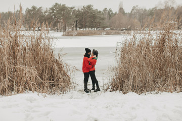  young couple in love walks through the winter forest and kiss