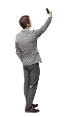 Back view of a businessman in a suit making a selfie.