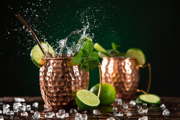 Famous splashing Moscow mule alcoholic cocktail in copper mugs. - Powered by Adobe