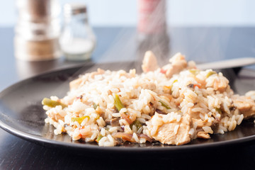 Close-up of a plate of steaming hot chicken and mushroom fried rice