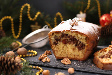 Christmas cupcake with nuts and candied, covered with icing sugar located on the Christmas background