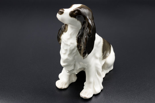 Antique porcelain figurine of a dog Spaniel breed on the black background