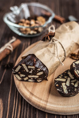 Chocolate sachocolate; sausage; background; wooden; baked; biscuit; board; breakfast; brown; butteusage on a wooden background. Dessert made of biscuits, chocolate and nuts is sliced on a wooden board