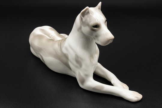 Antique porcelain figurine of a dog Deutsche Dogge breed on the black background