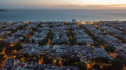 view of city city at dusk with tops and sea in the background
