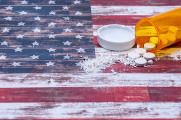 Opioid and drug addiction epidemic concept in America with pills and bottle and room for copy text