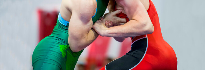Two wrestlers Greco-Roman wrestling during competition - obrazy, fototapety, plakaty