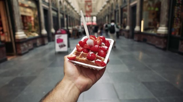 POV close up, person holds strawberry Belgium waffles
