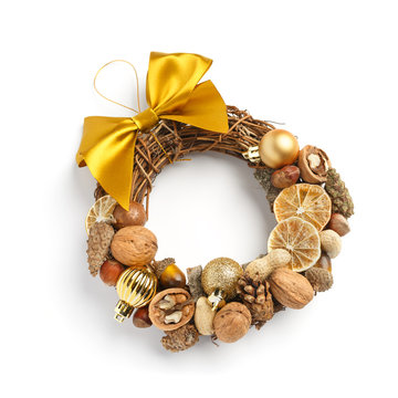 Beautiful Christmas wreath consisting of dried orange slices, nuts, cones, decorated with a large yellow bow on a white background