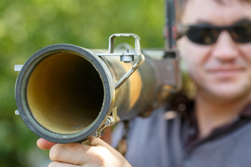 Mercenary in black glasses with anti-tank rocket launcher, RPG in hand. Close-up