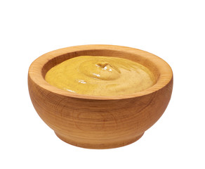 Mustard sauce in wooden bowl isolated on  white