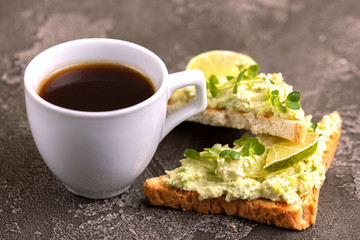 Toasts with avocado pate, fresh microgreen and cup of coffee