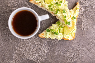 Toasts with avocado pate, fresh microgreen and cup of coffee
