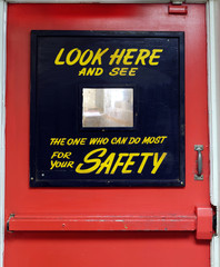 Close up of vintage Safety First industrial door with mirror gimmick.