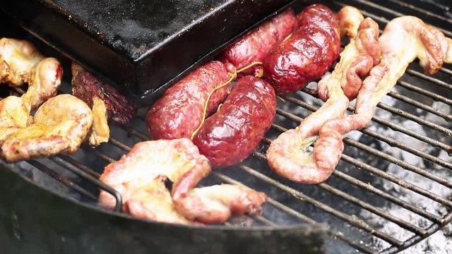 Close-up high angle of meat cooking on a barbecue grill Argentina with slight pendulum movements