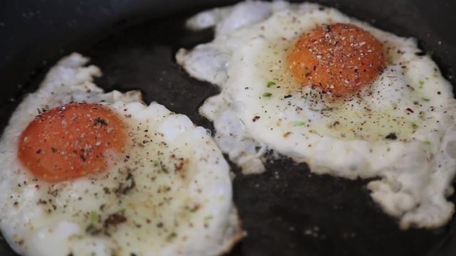 Eier werden in die Pfanne gegeben, gew&uuml;rzt und zu Spiegeleiern gebraten, full HD 1080p Video 25 fps Zeitraffer