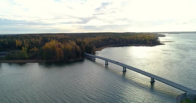 Car on a bridge, C4K aerial, drone shot, following a car driving on a asphalt road, form sarkisalo island to isoluoto island, in the archipelago, on a sunny day, in Varsinais-suomi, Finland