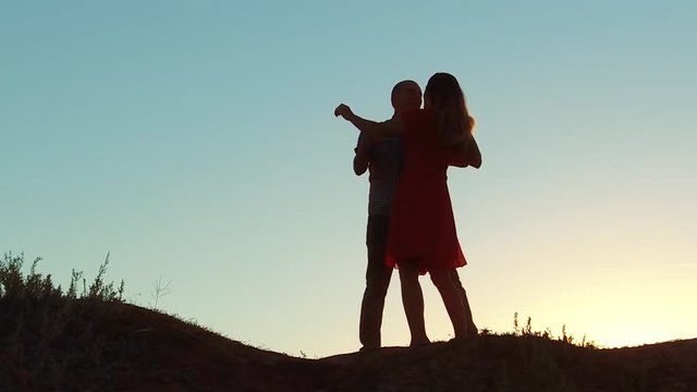 silhouette of a happy young married couple and dog slow dancing outside at sunset. slow motion video. man and girl dancing salsa at sunset. Unidentifiable lifestyle Silhouette of dancing couple love