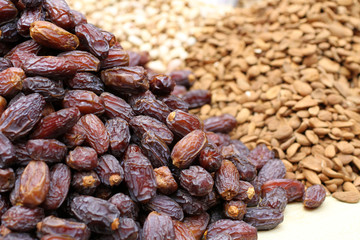 Big dried dates, raw almonds and cashews, lying on a large counter at the market in Deira, Dubai.