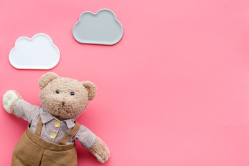 Baby care with craft toys for newborn. Teddy bear. Pink background top view copy space