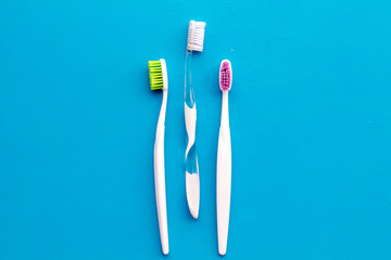 Daily oral hygiene for family. Toothbrush on blue background top view mock up