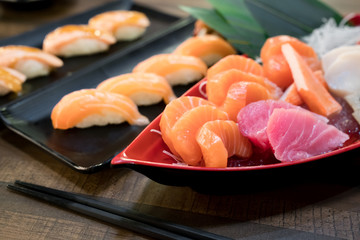 Mixed sliced fish sashimi on ice in white bowl. Sashimi Salmon Tuna Hamachi set, raw fish, japanese food in Asian restuarant. - obrazy, fototapety, plakaty