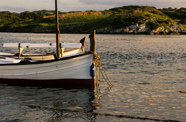 Traditional fishing boats at sunset on summer day. Cap Cavalleria, Menorca, Balearic islands, Spain,