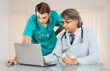 Male doctor prescribing drugs to patient on background