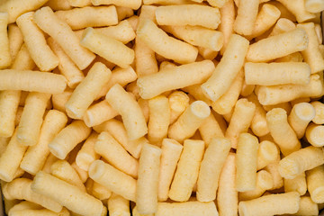 Salted corn puffs snack food texture background, close up detail
