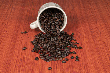 Coffee beans in white cup with wooden background