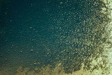 Water drops on car side glass in dusk and bokeh lights