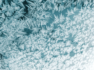 winter window pane coated by icy frost patterns. frosty winter background on glass 