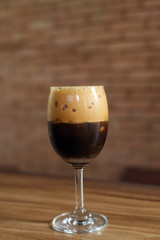 Iced coffee in glass on wooden table
